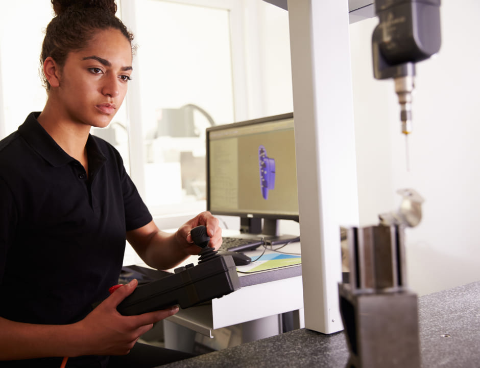 A woman in a black shirt is seen diligently operating a machine